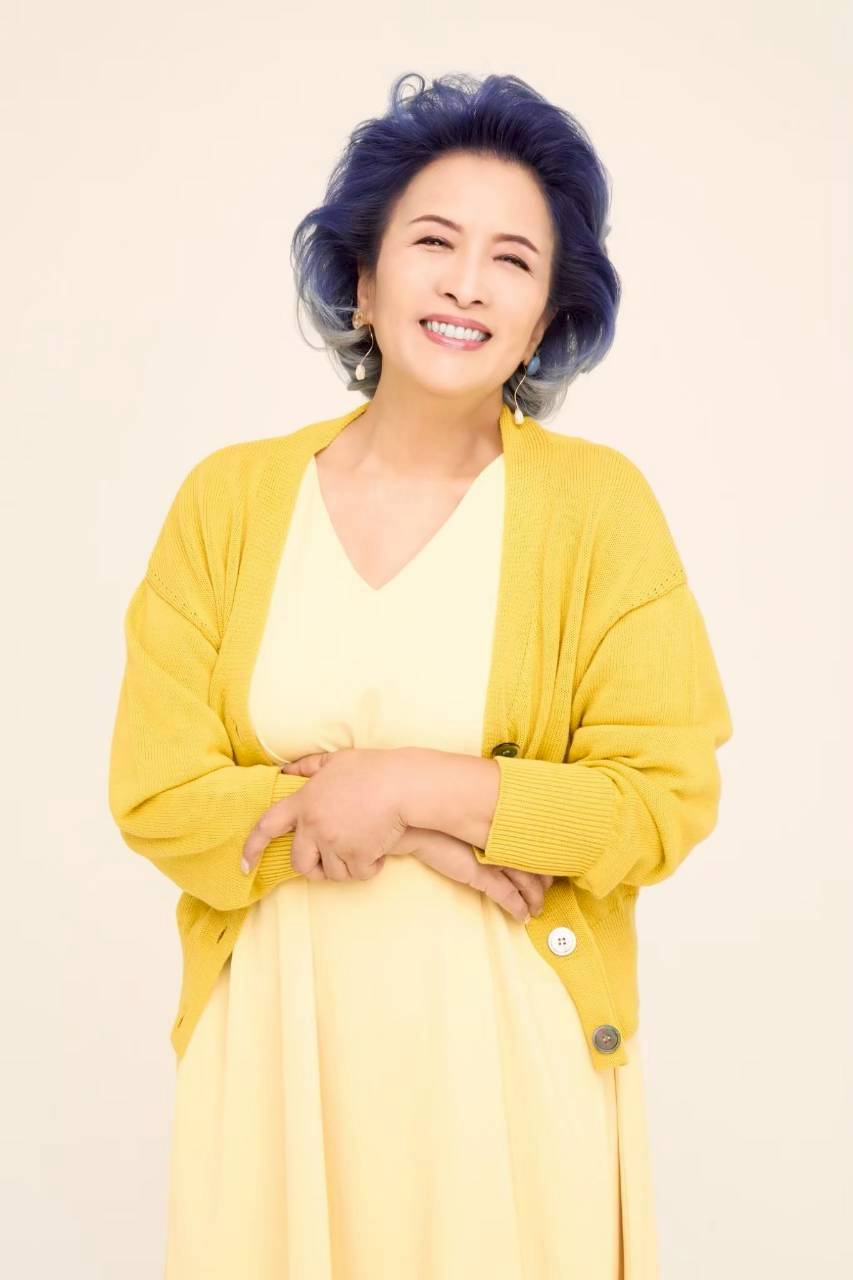 黄色のニットを着て、笑顔で迎える池上季実子